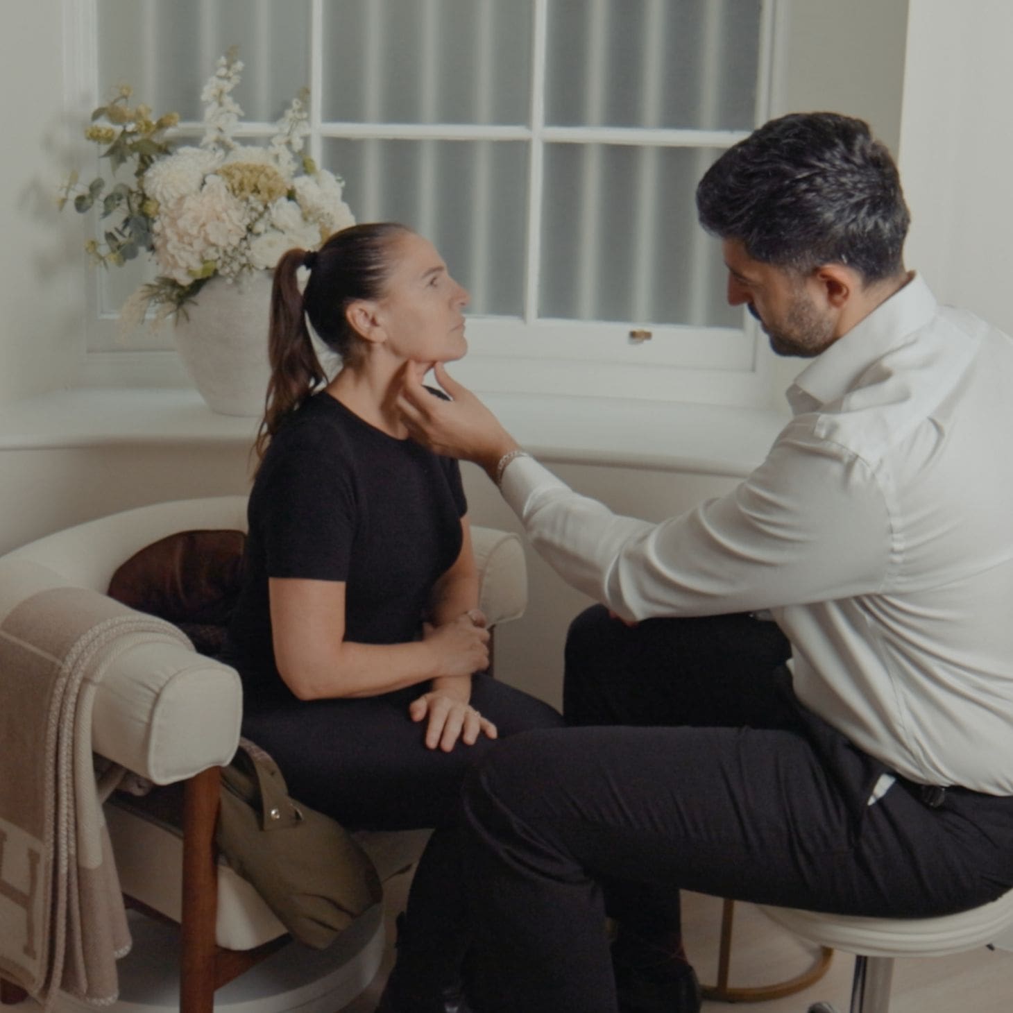 Dr Hass assessing a patient's jawline